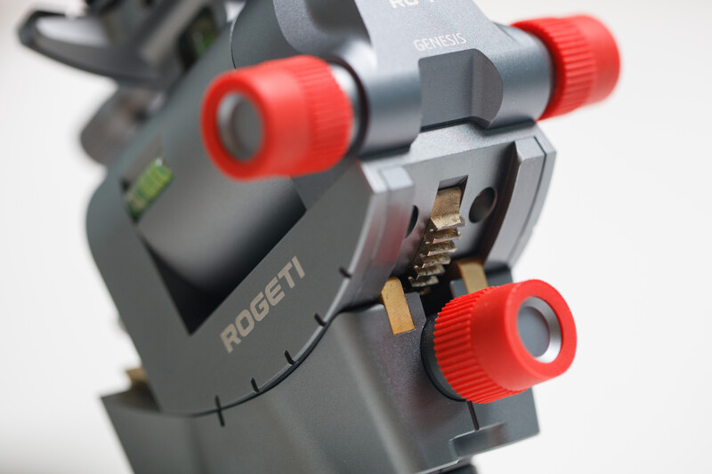 Close-up of a Rogeti camera tripod head with red knobs and adjustment mechanisms visible.