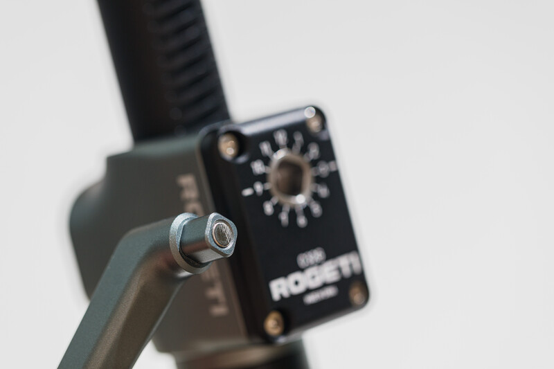 Close-up of a gimbal head mounted on a tripod with adjustment controls visible.