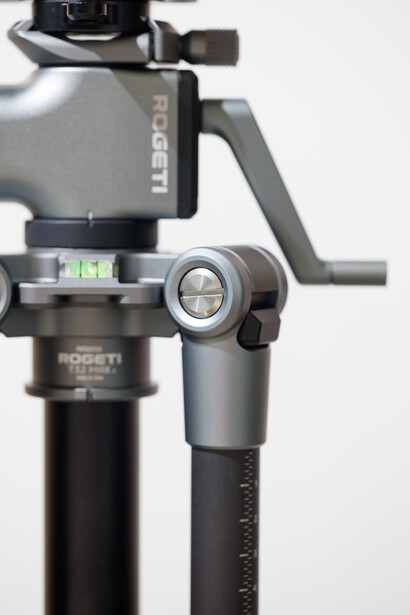 Close-up of a gimbal stabilizer head mounted on a tripod pole with adjustment controls visible.