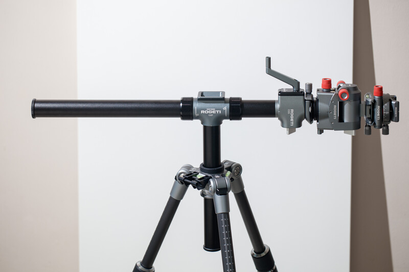 Telephoto lens with sun shade and mounting accessories on tripod against white background.