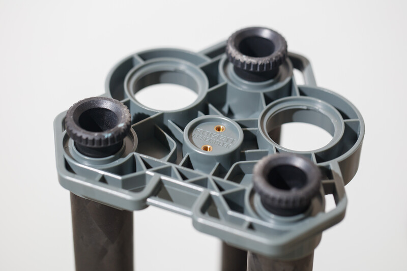 Close-up of gray plastic lens turret with four threaded lens mounts and central adjustment knob.