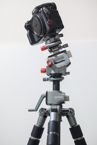 Professional camera mounted on tripod with multi-axis gimbal head and support arms.