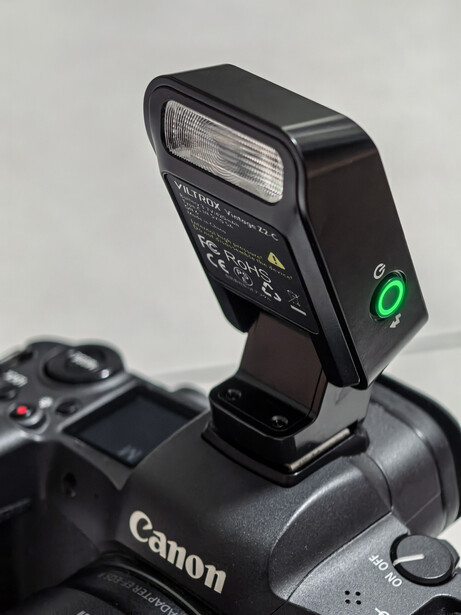 Speedlite flash unit mounted on top of a Canon DSLR camera body.