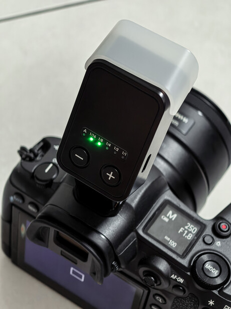 External flash with wireless trigger mounted on DSLR camera body.