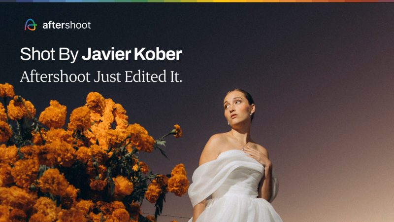 Woman in white strapless dress standing beside vibrant orange marigold flowers against a warm gradient backdrop.