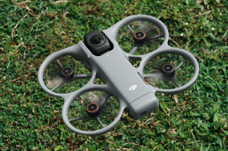 DJI Avata 2 compact drone with four propeller guards displayed on grass.