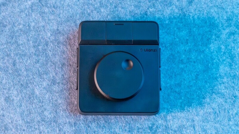 Dark blue dimmer switch with rotary knob against textured blue and white background.