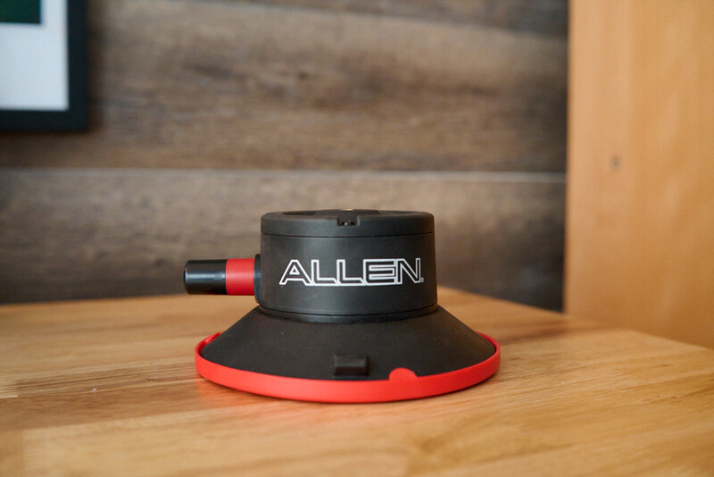 Allen suction cup tripod head with red grip base on wooden surface.