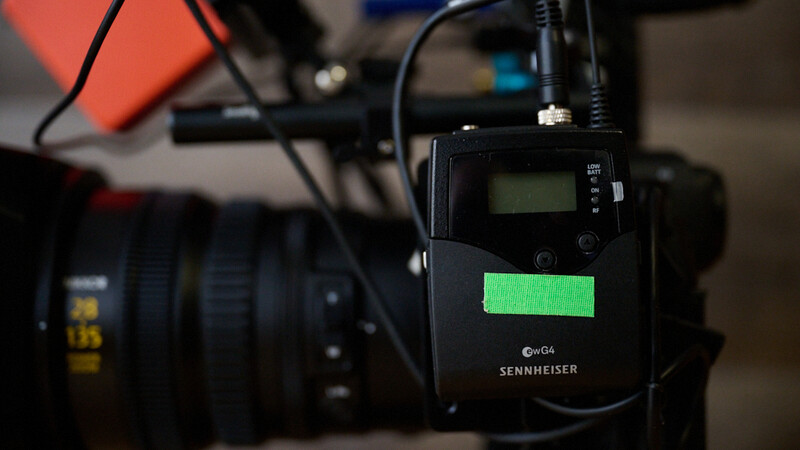 Sennheiser G3 wireless microphone receiver mounted on camera rig with green battery indicator illuminated.