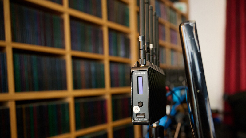 Wireless microphone transmitter mounted on a microphone stand with antennas extended.
