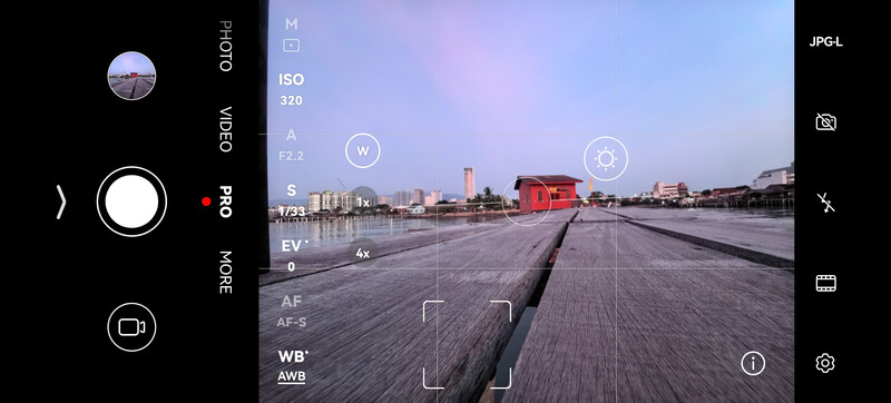 Screenshot of a smartphone camera app interface showing a waterfront industrial scene with perspective lines.