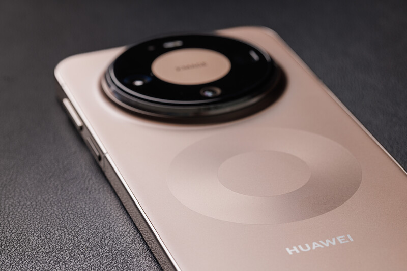 Huawei smartphone with large circular camera module on back, shot against gray surface.