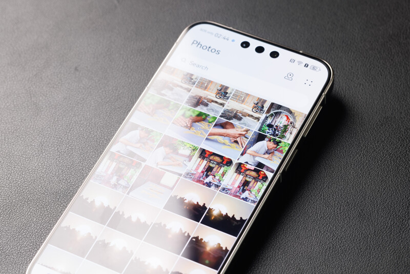 Smartphone displaying a photo gallery grid with multiple thumbnail images and varied lighting conditions.