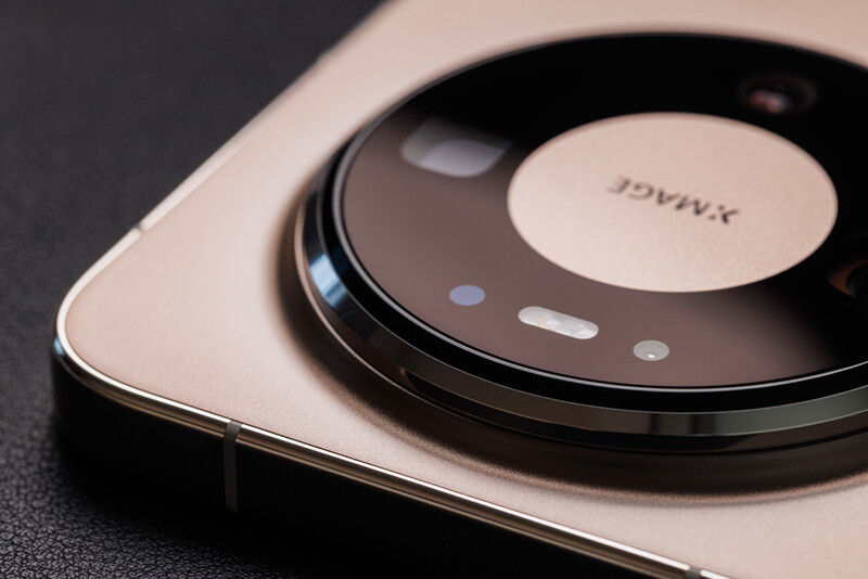 Close-up of a smartphone camera module with circular lens array and branding on champagne-colored device body.