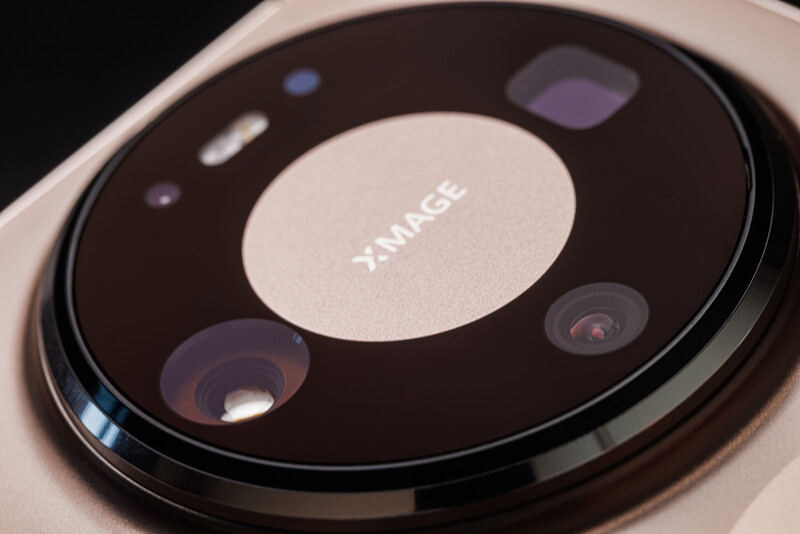 Close-up of a smartphone camera module with multiple lenses arranged in a circular pattern on a dark background.