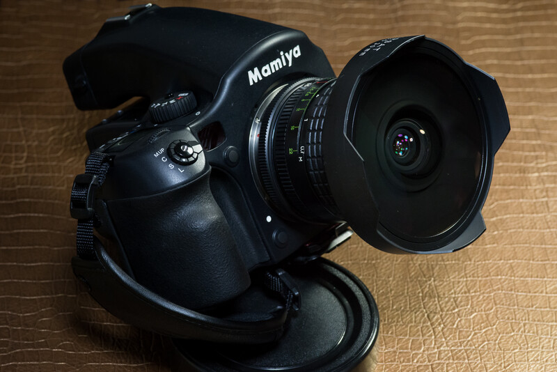 Mamiya medium format camera with wide-angle lens attached, photographed on a wooden surface.