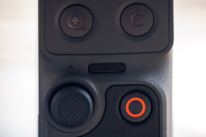 Close-up of a smartphone camera module showing dual rear lenses and control buttons with an orange accent.
