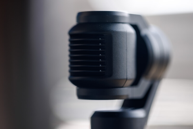 Close-up of a black gimbal stabilizer head with articulated mounting arms and control mechanisms.