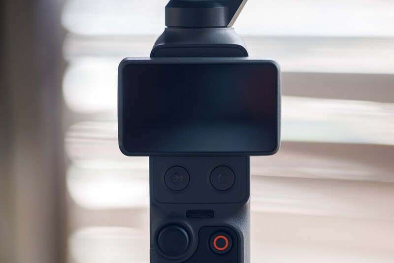 Close-up of a gimbal stabilizer with smartphone mounted on top and control buttons visible below.