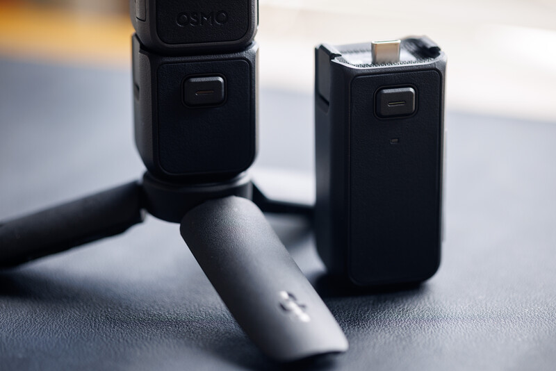 DJI drone remote controller and battery pack displayed on a neutral surface with soft directional lighting.