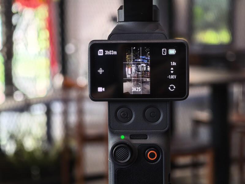 Smartphone mounted on a tripod head displaying thermal or infrared camera feed with temperature readings and interface controls.