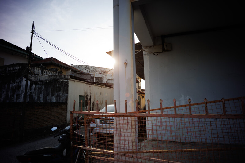 Industrial urban scene with concrete pillar and metal safety fence at golden hour.