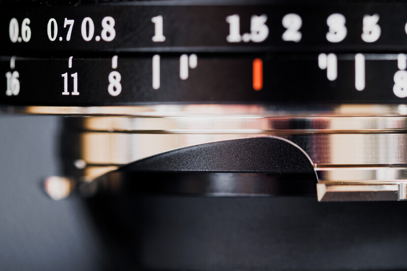 Close-up of a camera lens aperture ring showing f-stop markings from f/0.6 to f/5.6.
