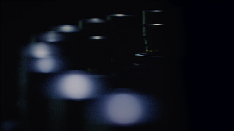 Out-of-focus studio lights arranged in a row against a dark background, creating soft bokeh circles.