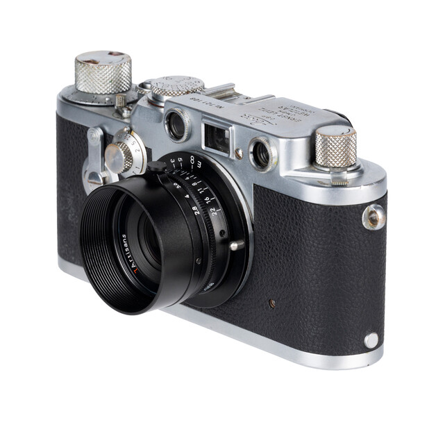 Vintage rangefinder camera with black leather body, chrome top plate, and fixed lens.