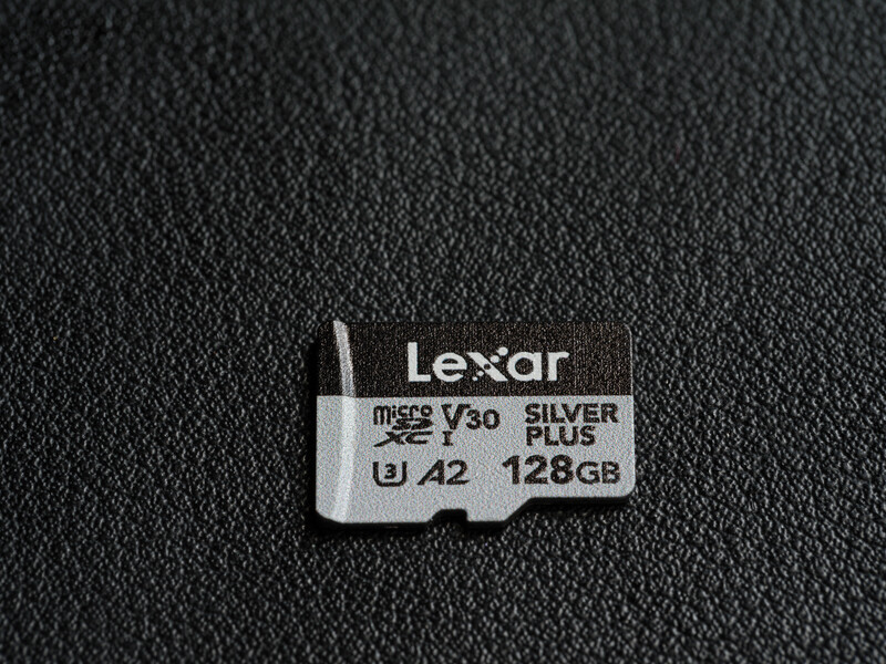 Lexar Silver Plus microSD card with 128GB capacity, V30 speed class, and A42 rating on dark textile surface.