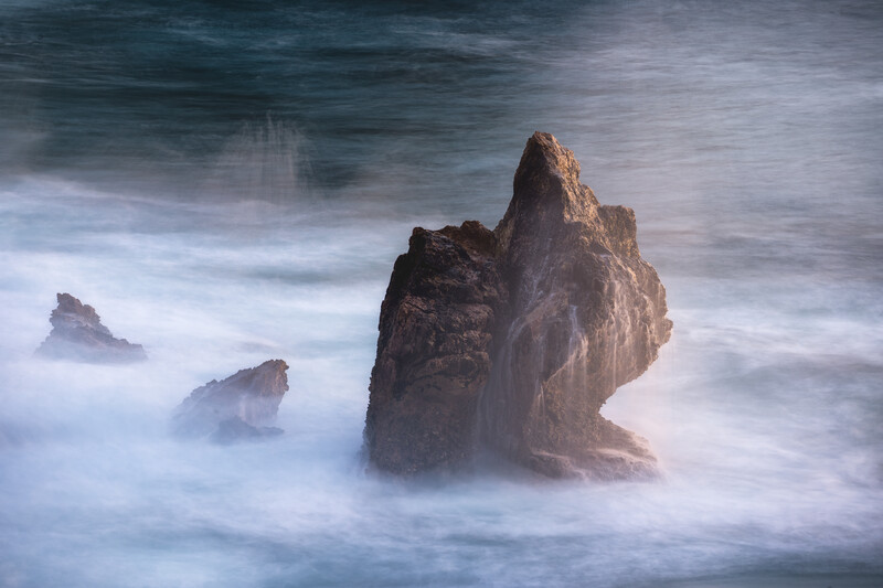 Long exposure of water hitting a lonely rock