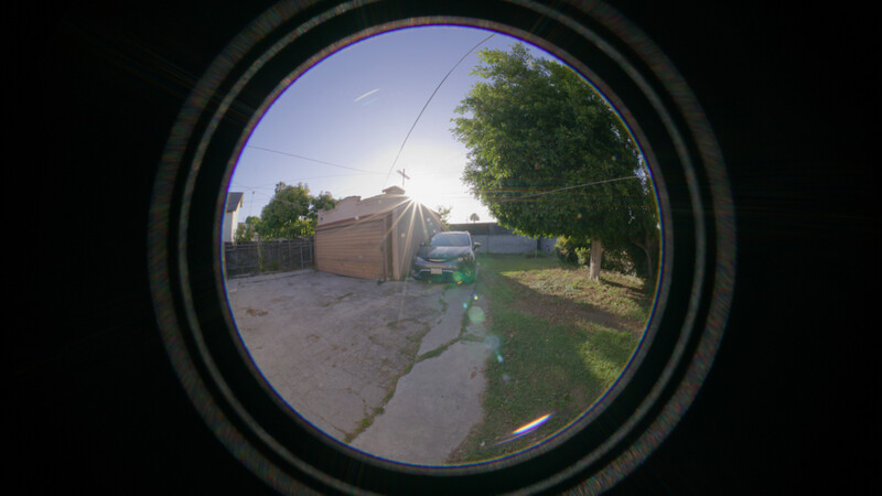 Fisheye lens view of a residential driveway and garage during golden hour.