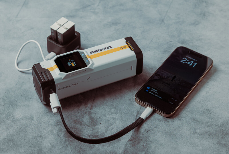White power bank with brown accents connected via USB cable to a smartphone displaying the time 2:41.