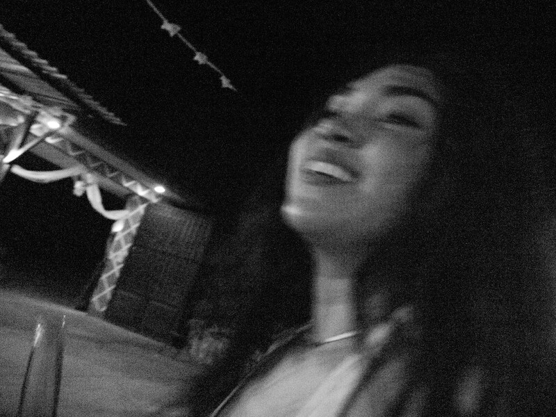 Black and white portrait of a woman singing into a vintage microphone with emotional expression