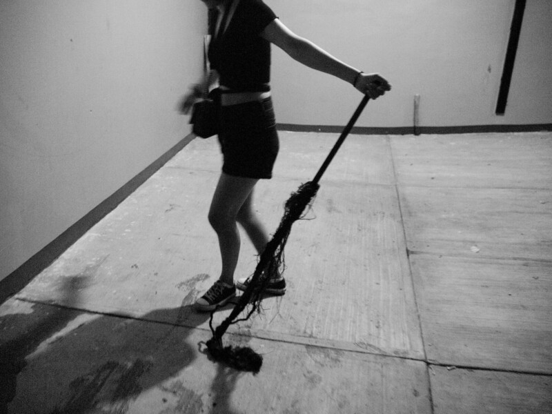 Silhouetted figure riding electric scooter on indoor concrete floor