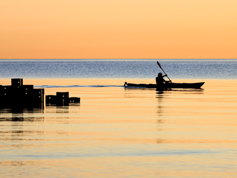 Silhouette photo of early morning kayaker on Lake Michigan