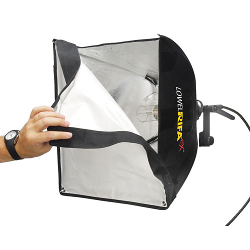 Photographer's hand opening a black fabric softbox with diffusion panel attached to lighting equipment