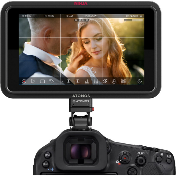 Atomos monitor mounted on camera showing video playback interface with grid overlay