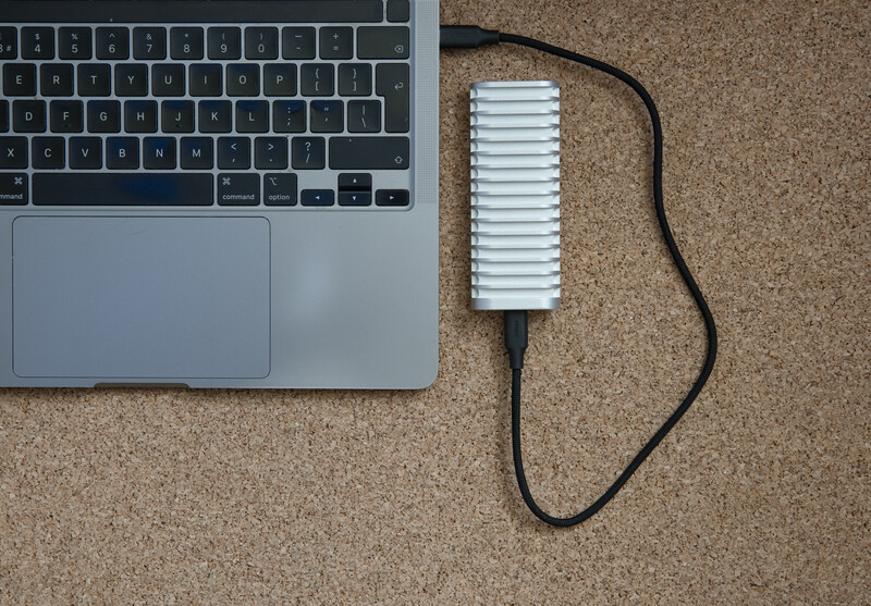 Laptop and external hard drive with cooling fins on cork surface