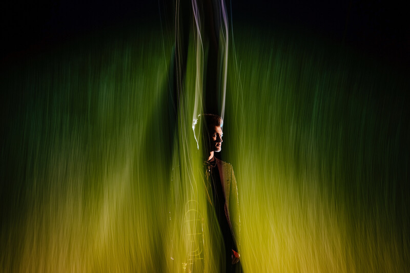 Person suspended between two vertical fabric ribbons with motion blur background