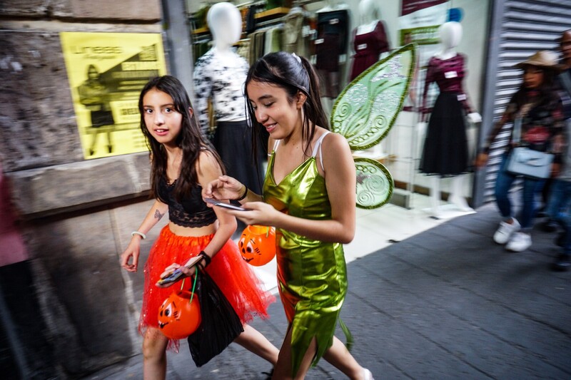 Two young girls in costume playing together in an indoor space with motion blur