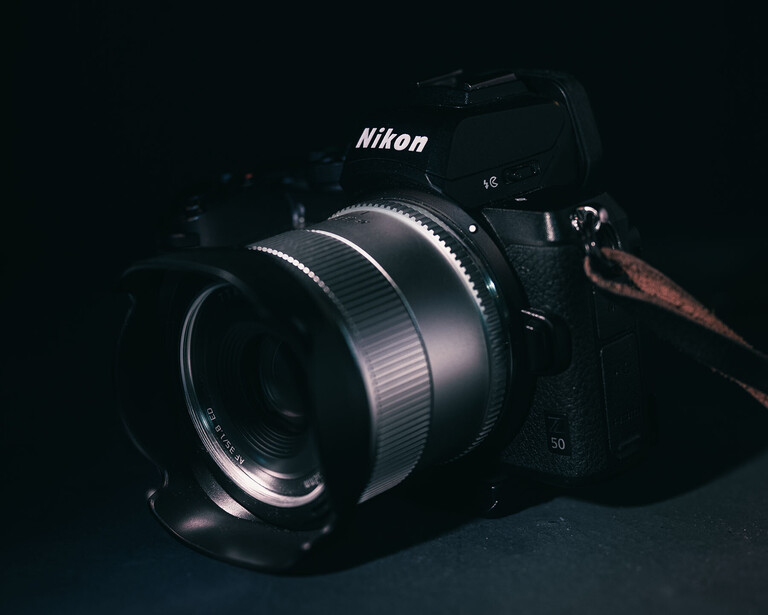 Nikon mirrorless camera with fast prime lens against dark background