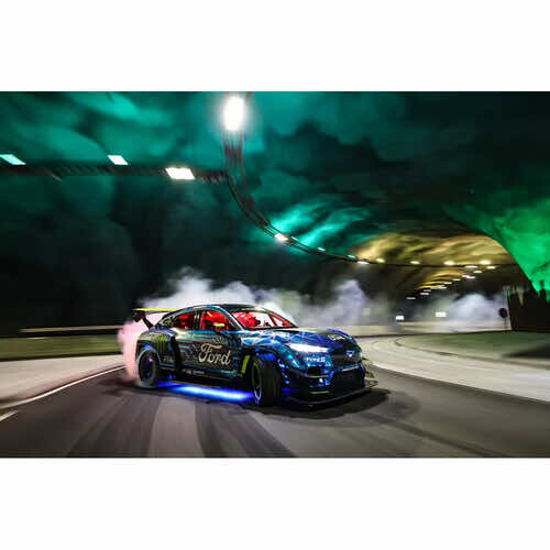 Blue sports car performing a drift with smoke under nighttime highway lighting