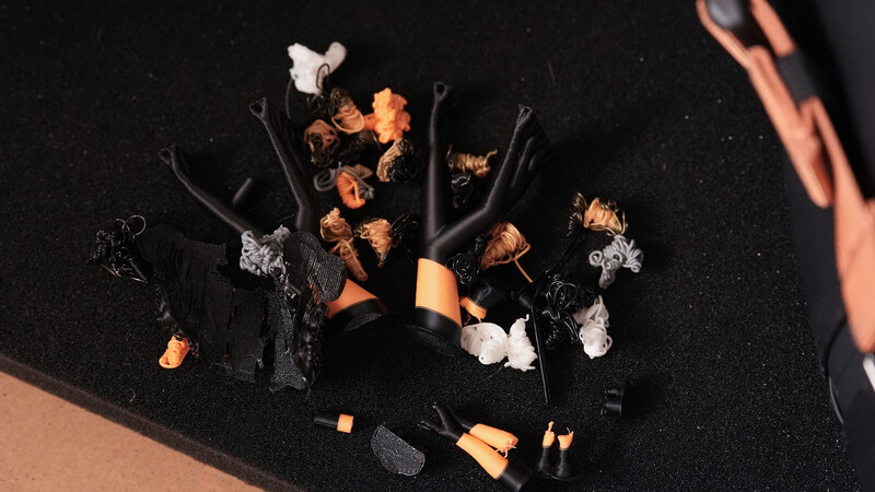 Flat lay of burnt flowers and cosmetics arranged on black background with warm sidelight