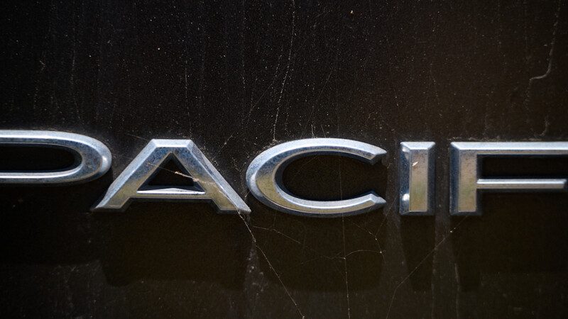 Close-up of metallic "PACIFIC" text with 3D chrome lettering on dark textured surface