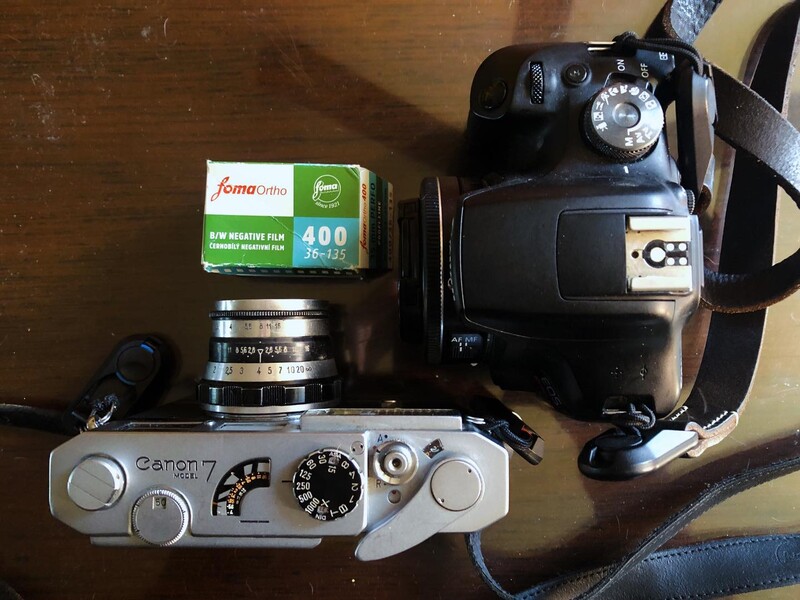 Collection of vintage film cameras and accessories arranged on wood surface