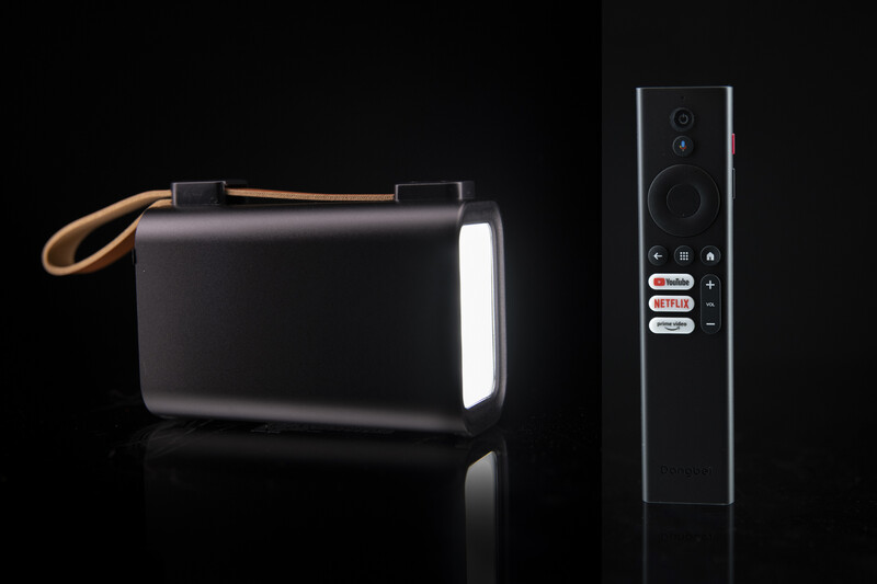 Portable LED light panel with carrying strap next to remote control on black background