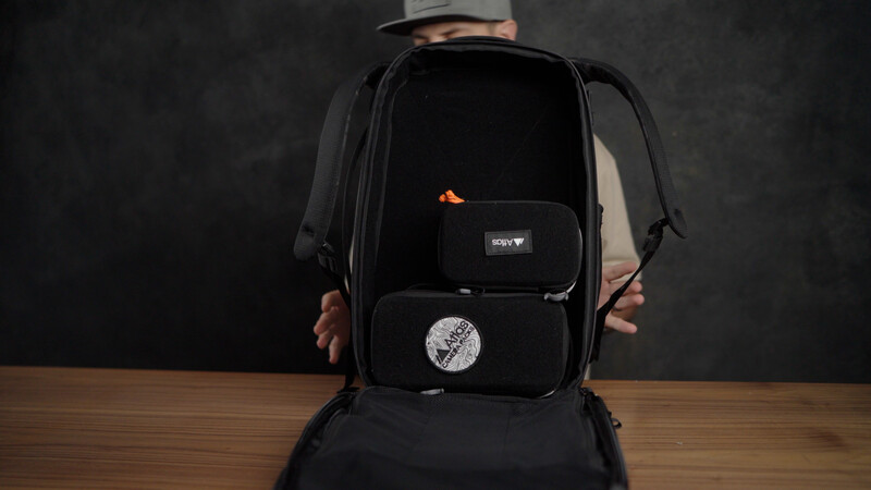 Open camera backpack displaying organized compartments with photography gear and accessories