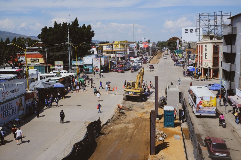 Urban street scene with construction equipment and pedestrians in an African town