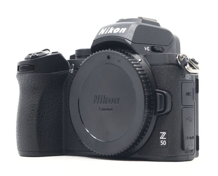 Nikon Z50 mirrorless camera body with lens cap and grip, displayed against white background